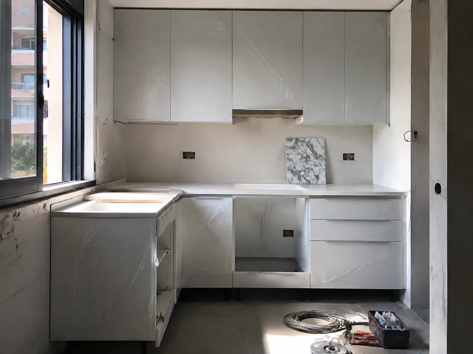 Cocina en montaje con muebles protegidos e instalaciones pendientes de rematar Cocina en montaje con muebles protegidos e instalaciones pendientes de rematar